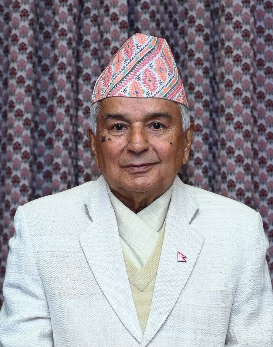 Official portrait of Nepal's President Ram Chandra Poudel wearing a traditional Dhaka topi and white coat, against a floral-patterned backdrop.