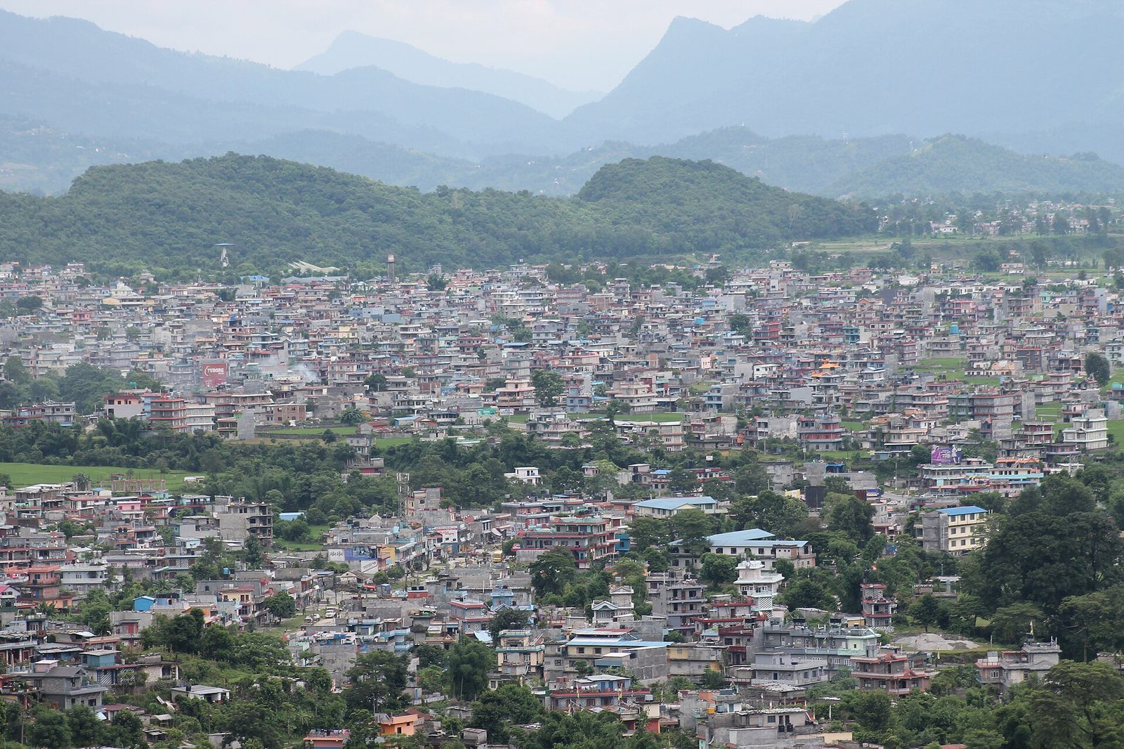 A view of Pokhara city in Nepal with hills in the background.