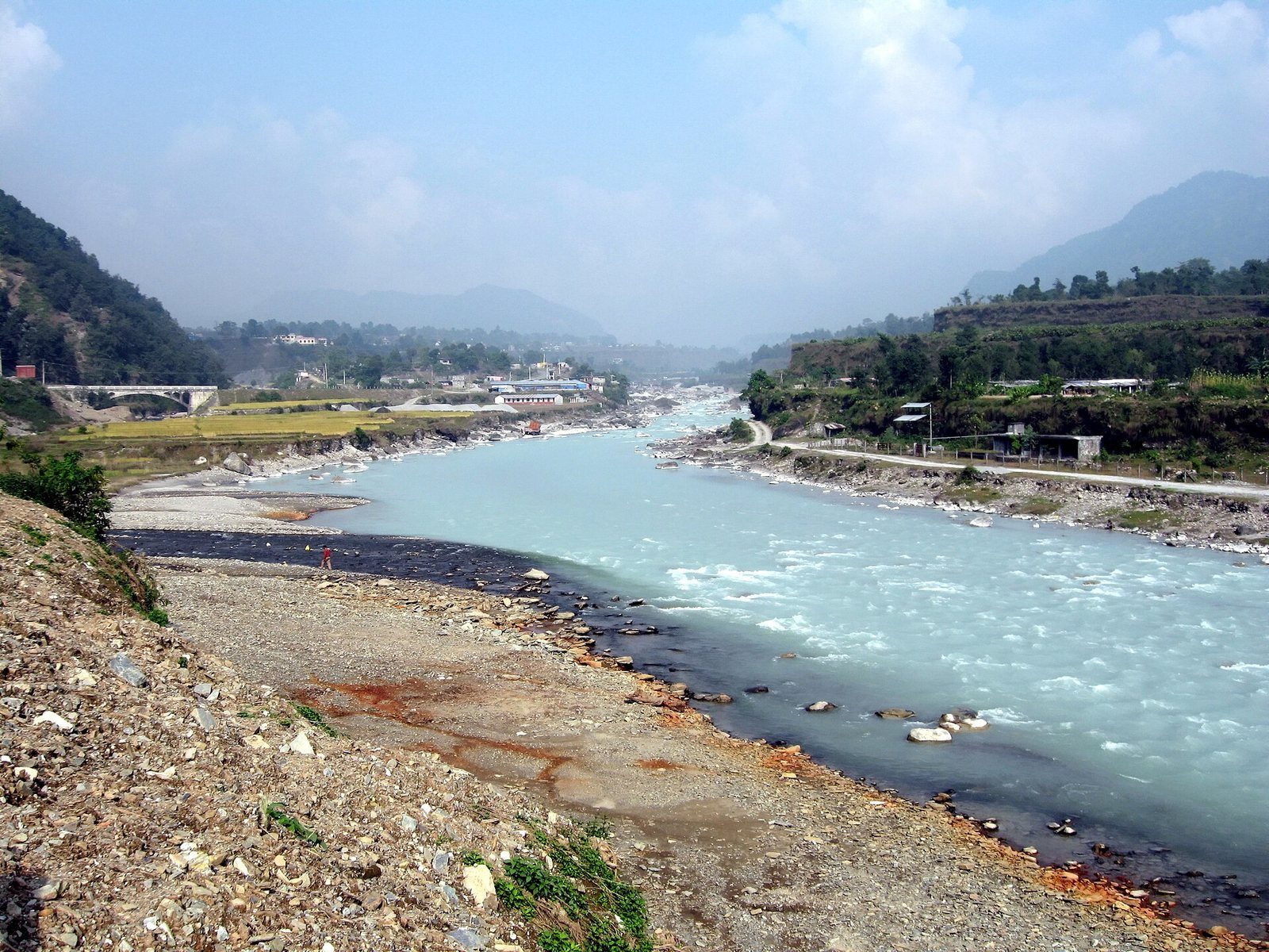 A wide, pale turquoise stretch of the Seti River flowing through a rocky gorge near Pokhara, with no people visible.
