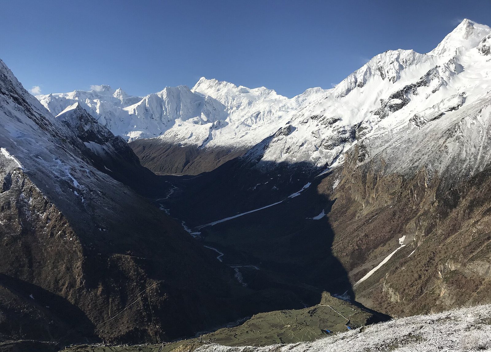 A view down the steep Budhi Gandaki valley in Nepal with snow-capped Manaslu peak visible in the distance.