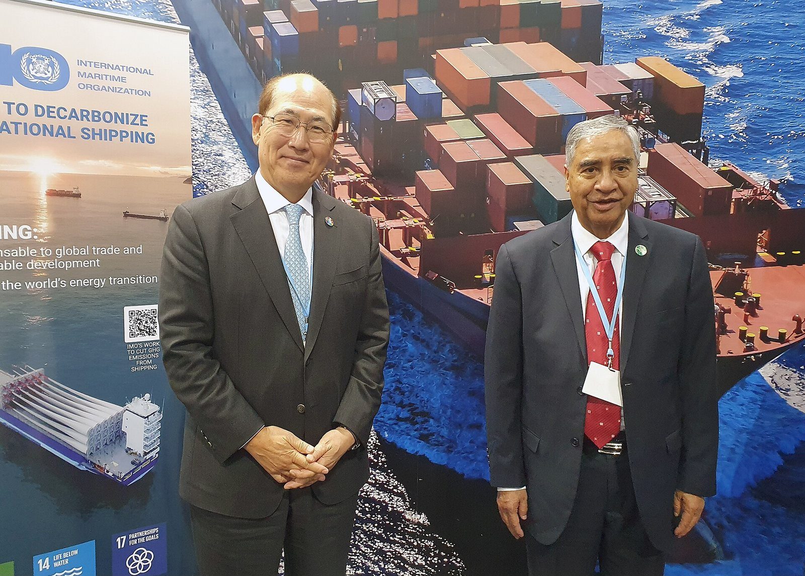 Sher Bahadur Deuba, in a suit, sits in conversation with IMO Secretary-General Kitack Lim in front of a shipping-themed backdrop.