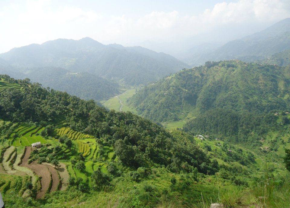 A green, terraced hill landscape in the Chure range of Udayapur District, Nepal, representative of the terrain along the Madan Bhandari Highway.