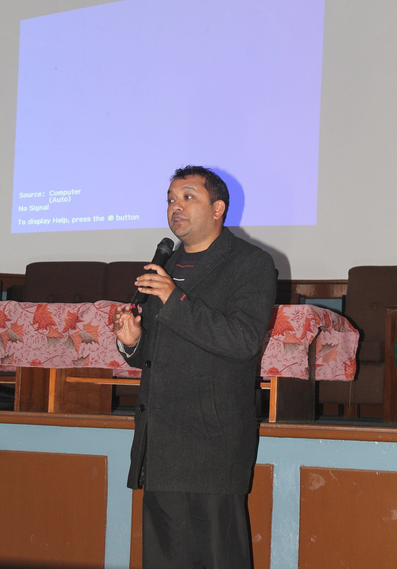 Gagan Thapa speaking into a microphone at a podium during a public event.