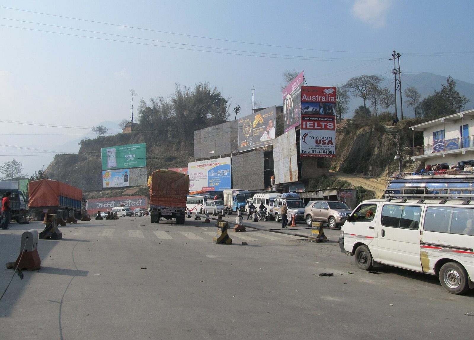A mountain pass road at Thankot on the edge of the Kathmandu Valley, with vehicles traveling along the Tribhuvan Highway.