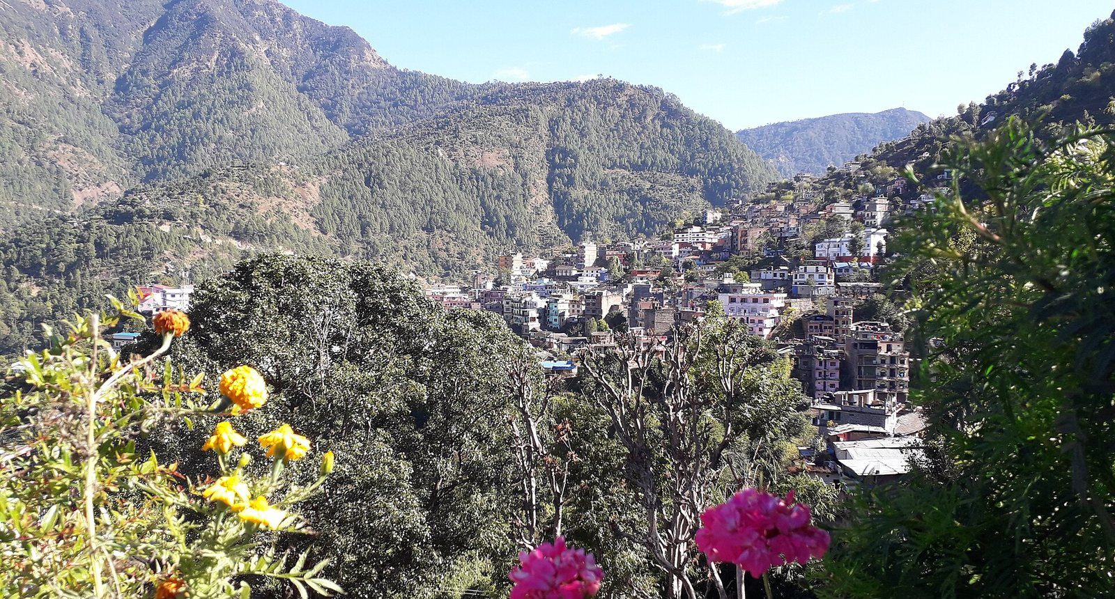 A scenic daytime view of Liwang, the headquarters town of Rolpa District, nestled among green hills.